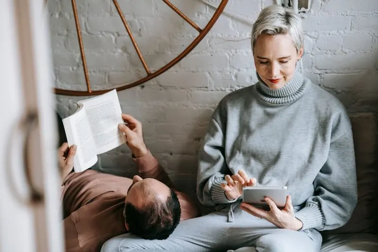 Hombre Virgo y mujer Piscis: detalle y sensibilidad Hombre Virgo y mujer Piscis leyendo juntos en un salón acogedor
