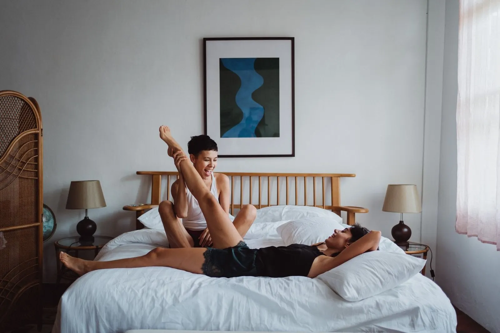 Pareja descansando en la cama con luz de mañana, intimidad tranquila y sensual