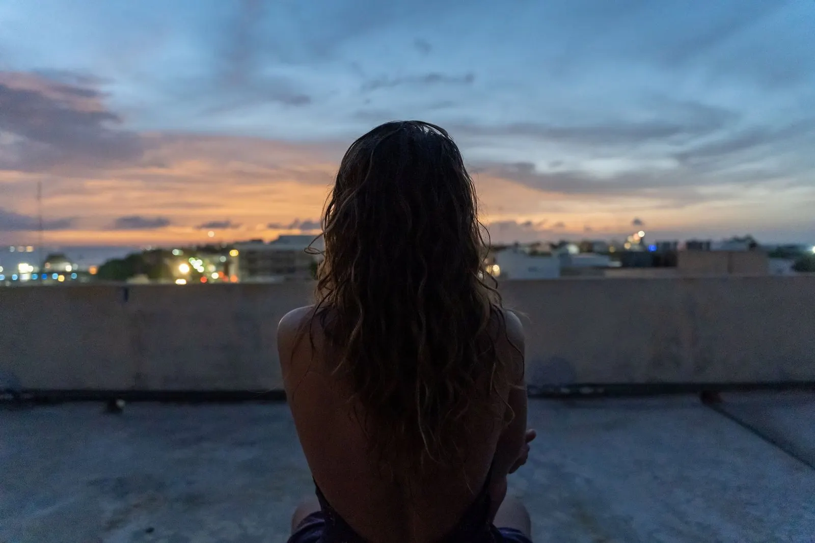 Mujer sola contemplando el atardecer en un momento de reflexión interior y calma