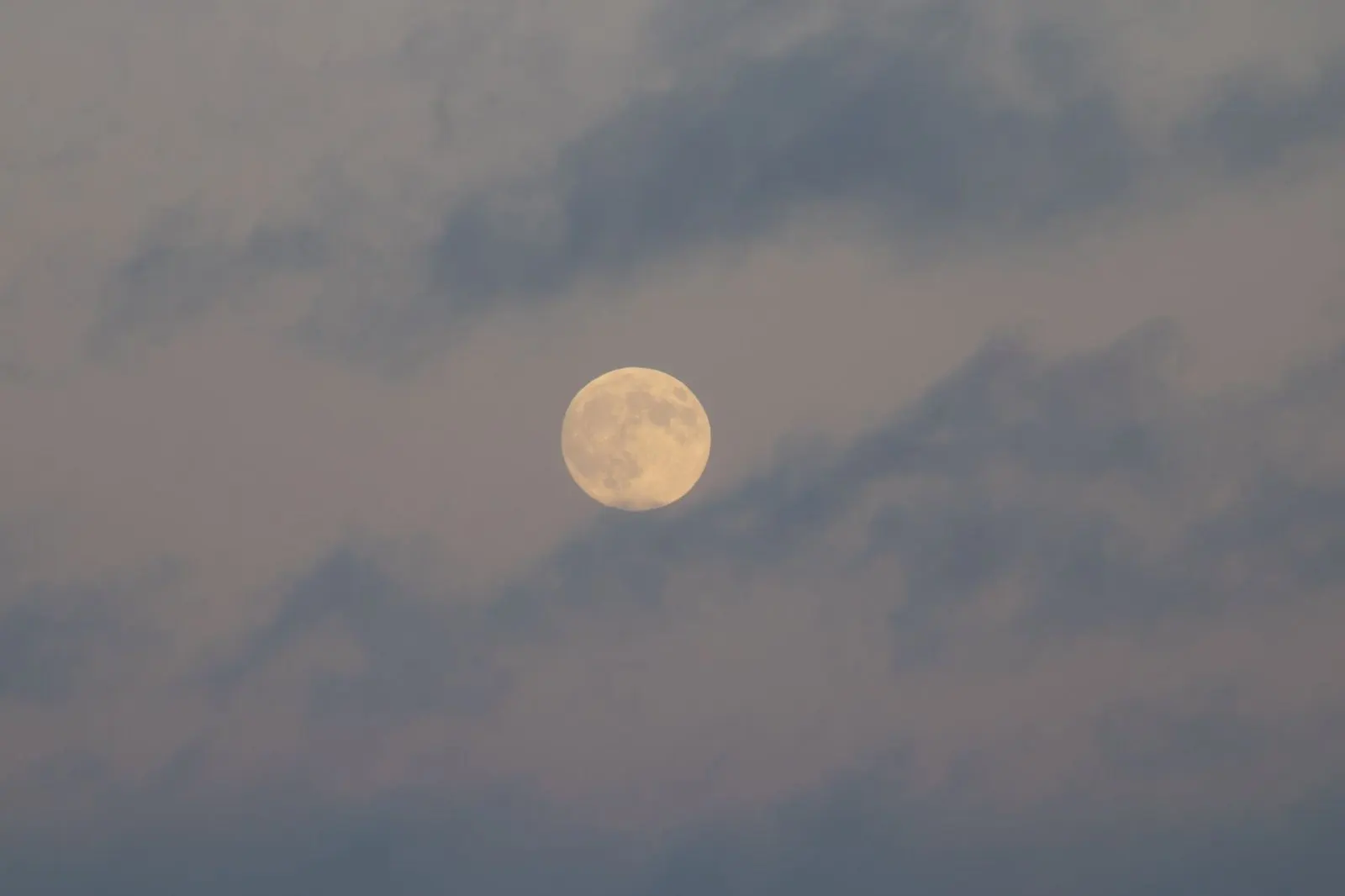 Luna llena entre nubes en el cielo nocturno, símbolo de las emociones cambiantes de Géminis