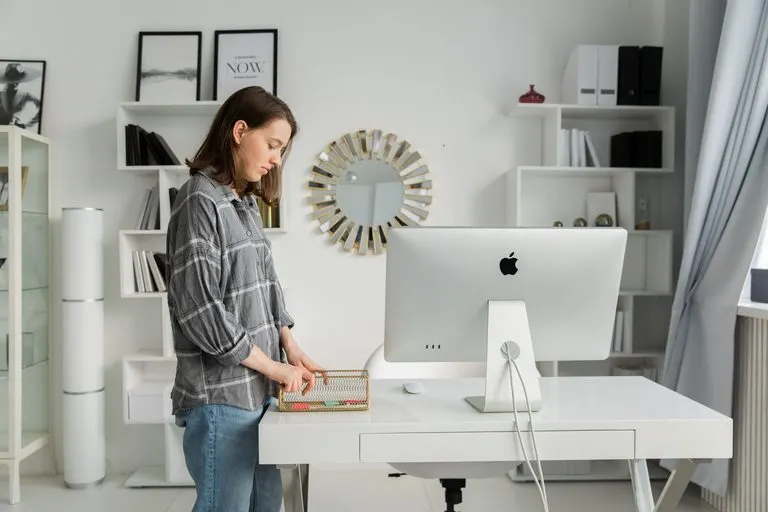 Mujer ordenando su escritorio con calma, reflejo de la Luna en Virgo