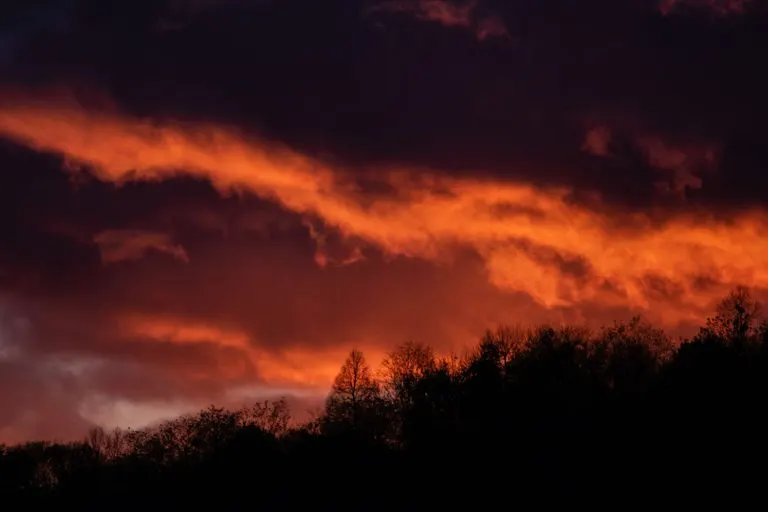 Marte en Aries: deseo, carácter y cómo conquista Silueta ante un atardecer rojo que evoca la energía de Marte en Aries