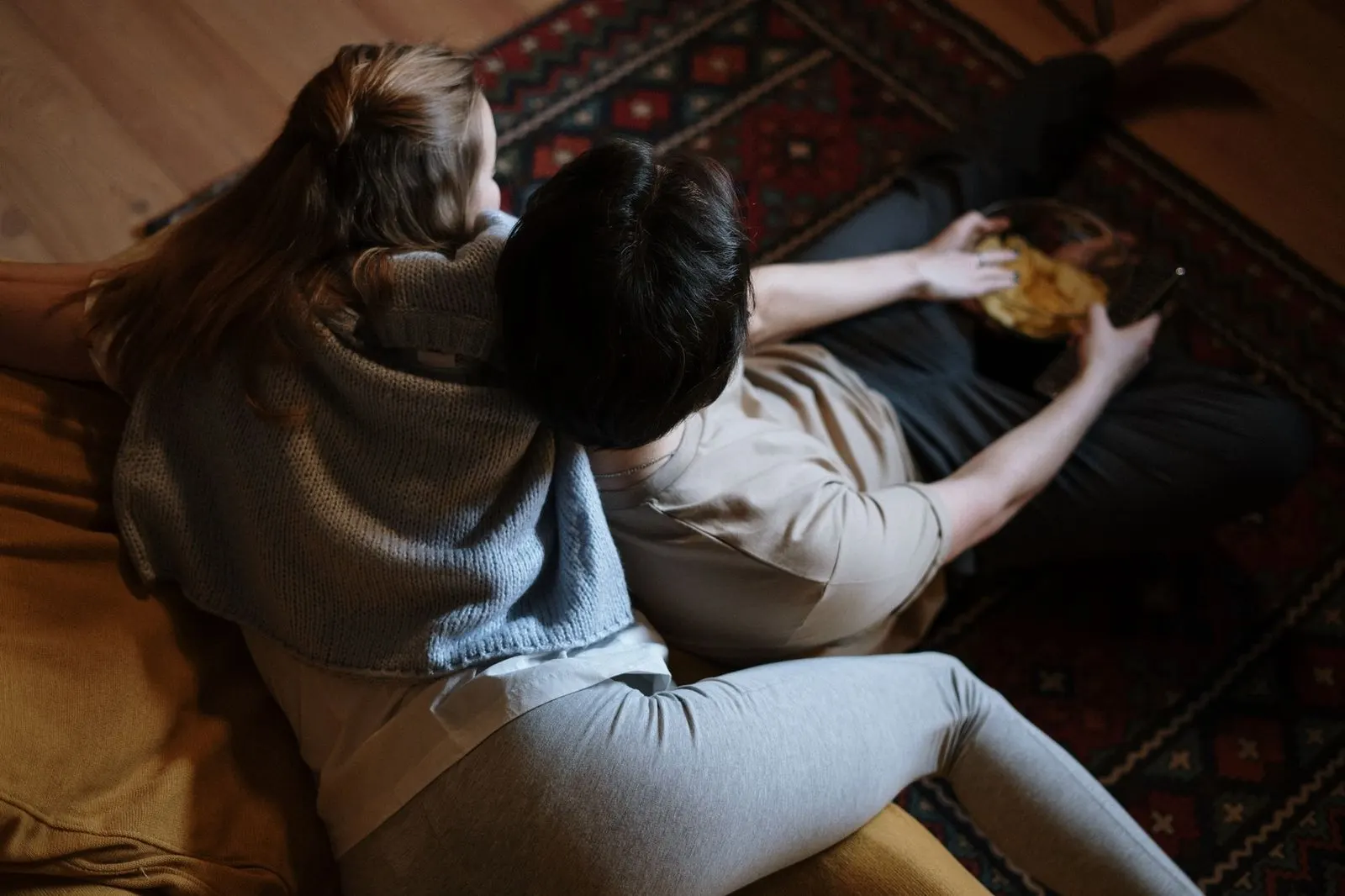 Pareja sentada en extremos del sofá, distancia emocional durante Marte retrógrado 2027