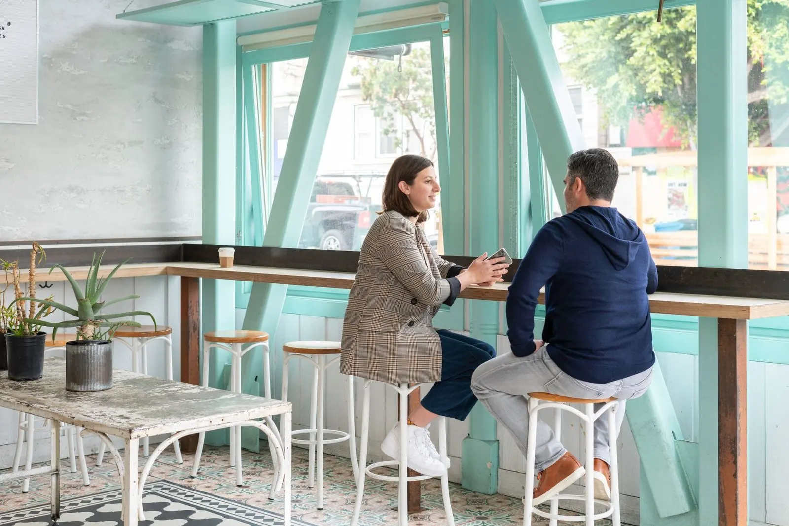 Pareja conversando en una cafetería, más allá de cualquier porcentaje de compatibilidad de signos