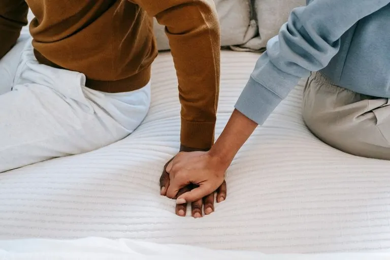 Pareja tomada de las manos con intensidad, símbolo de una relación kármica