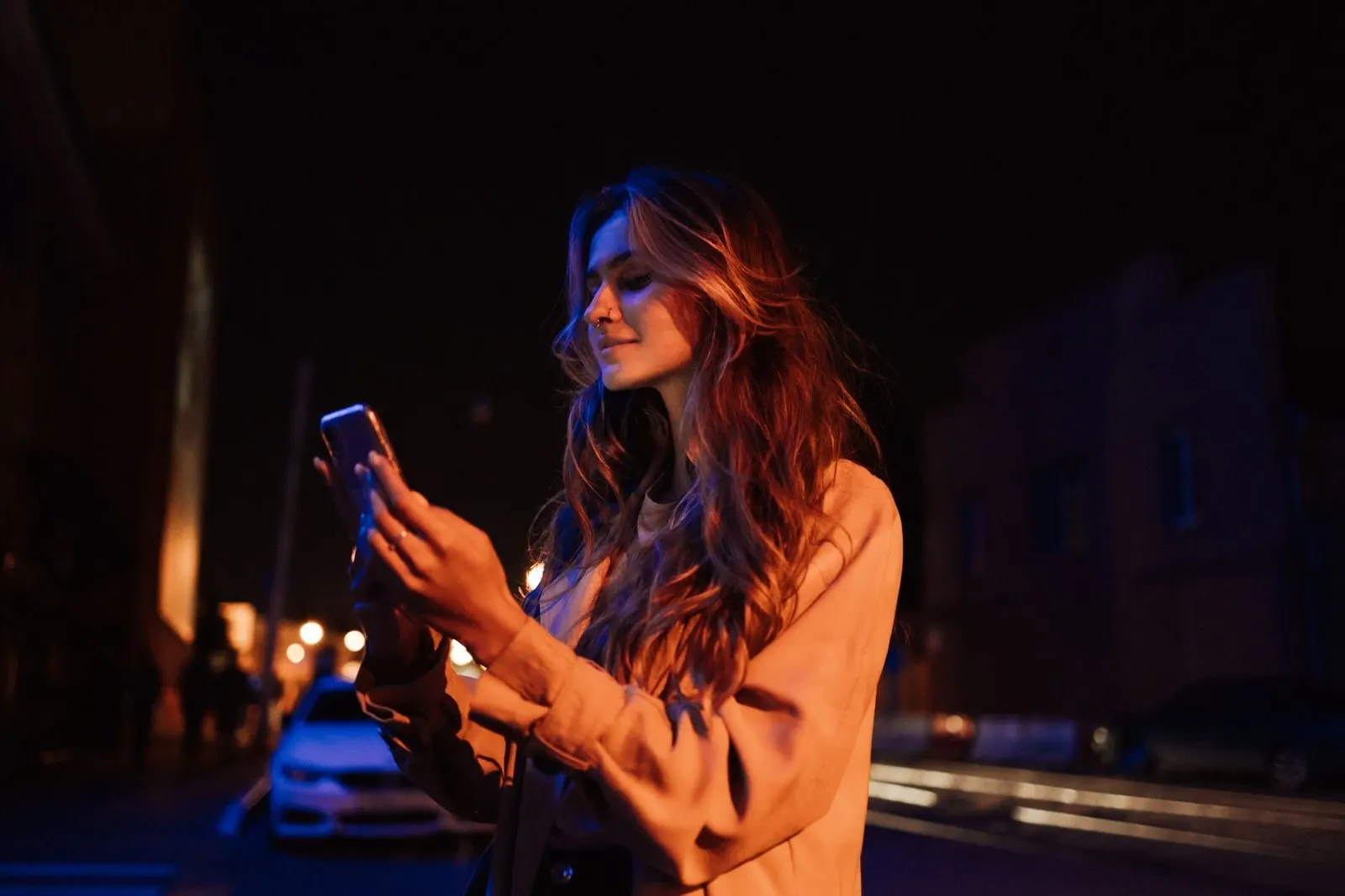 Mujer mirando el móvil de noche, cómo saber si un Géminis te extraña