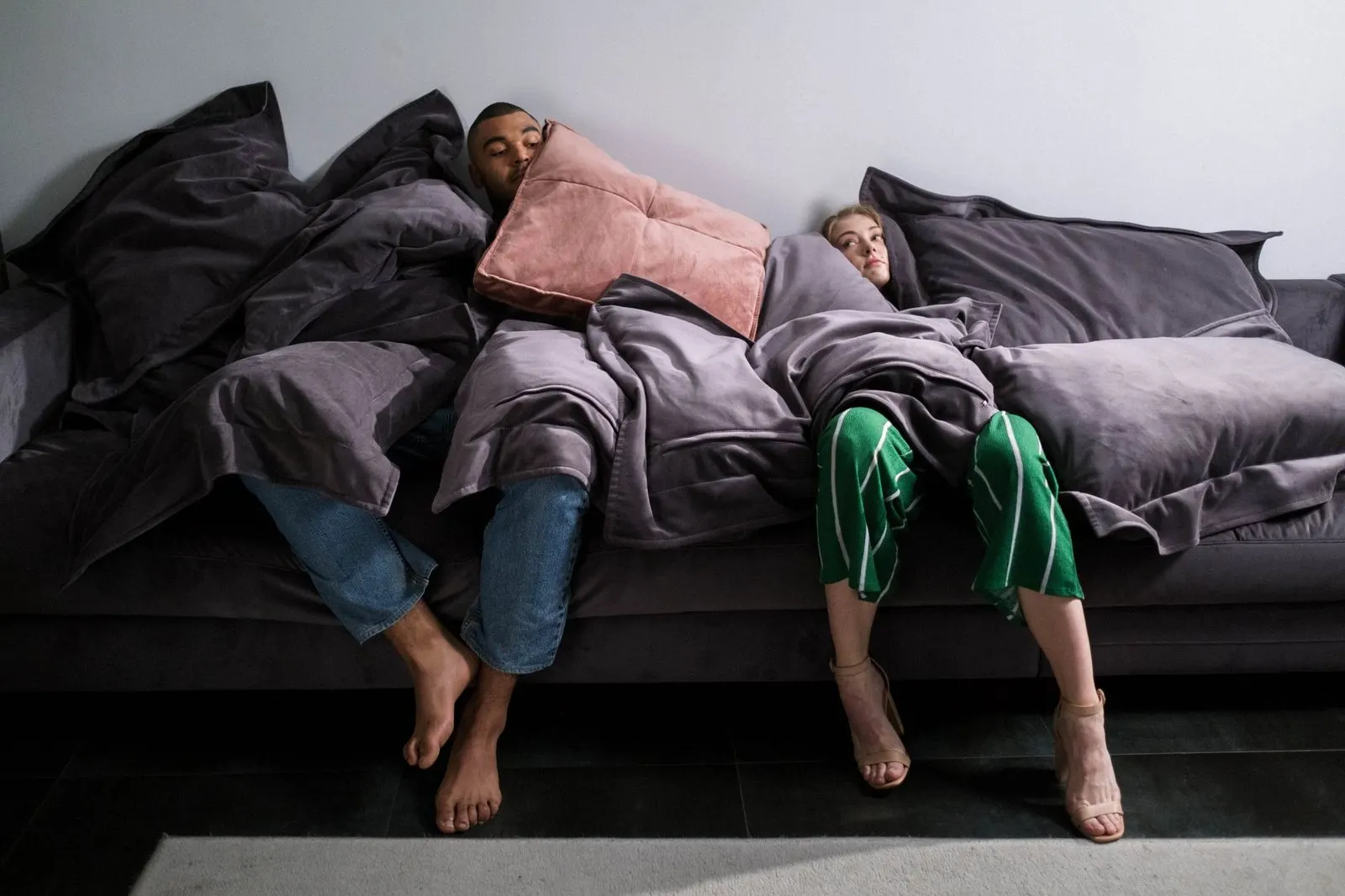 Pareja relajada en el sofá con una manta, la calma de un Tauro enamorado