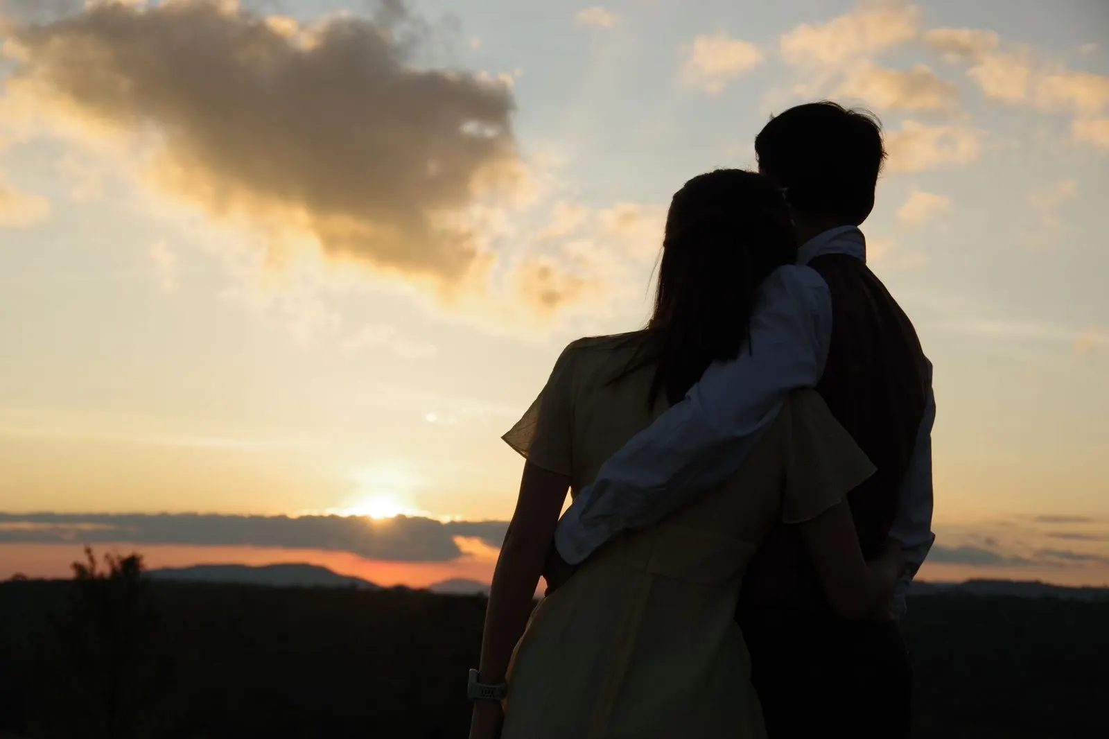 Pareja abrazada al atardecer como imagen de signos que se complementan en el amor