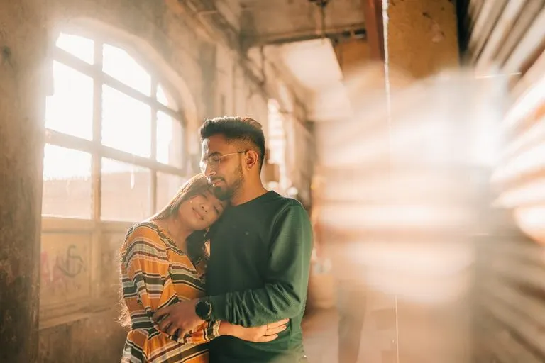 Pareja abrazada bajo luz cálida que evoca la sinastría Luna en casa 1