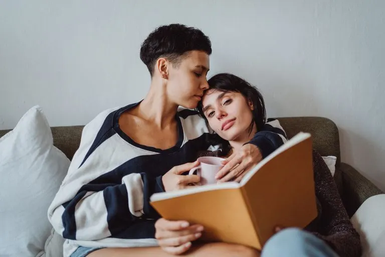 Pareja abrazada en el sofá de casa, reflejo de la sinastría Luna conjunción Ascendente