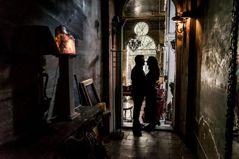 Pareja abrazada en penumbra que evoca la intimidad de la sinastría Venus casa 12