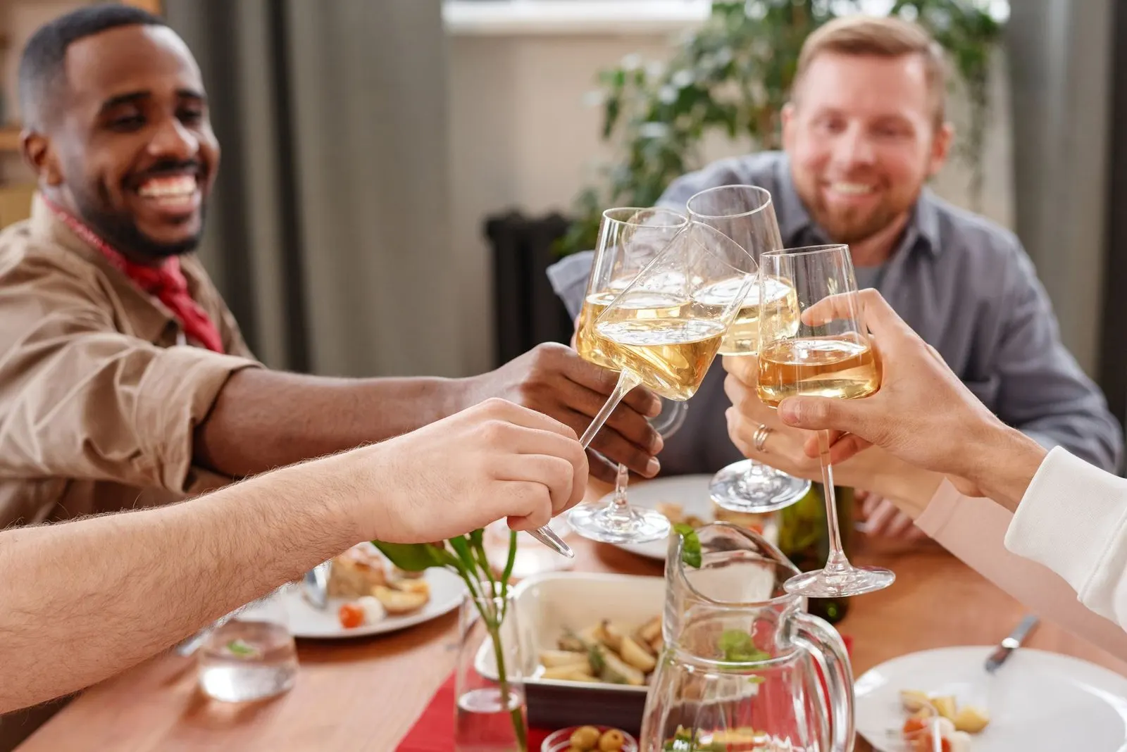 Amigos brindando en casa, celebración que encarna la generosidad de Venus y Júpiter
