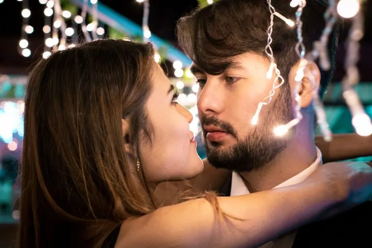 Pareja mirándose con intensidad, reflejo de la sinastría Venus oposición Marte