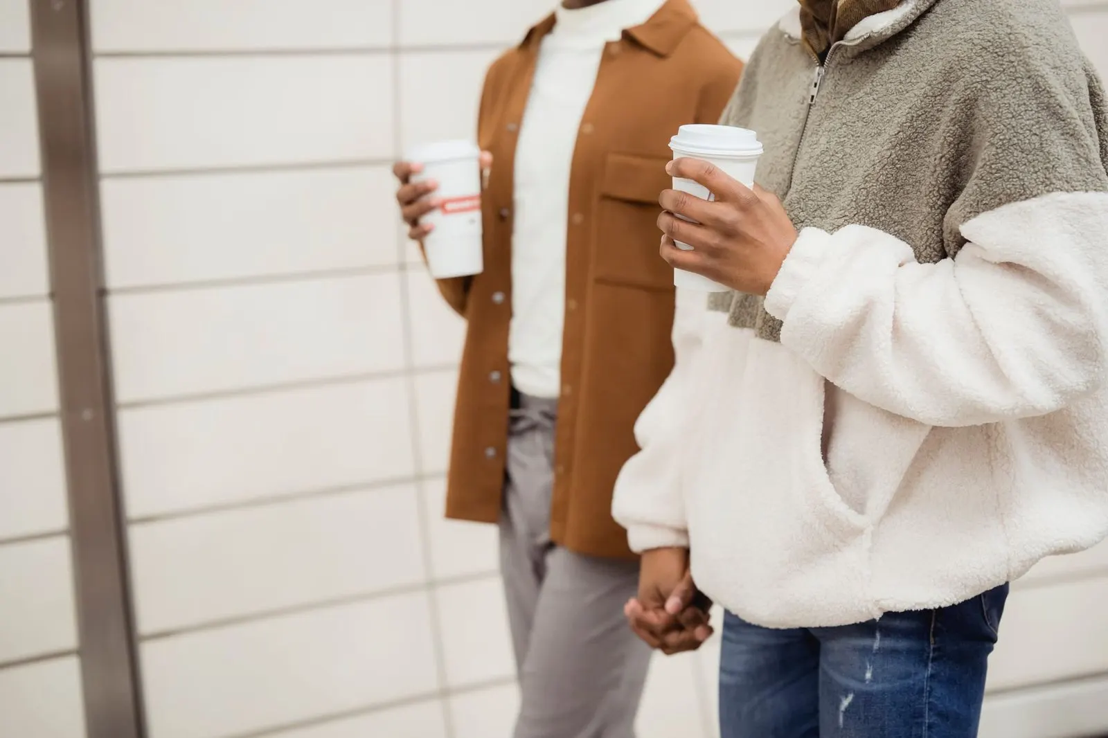 Manos de una pareja sujetando tazas de café en una mañana tranquila