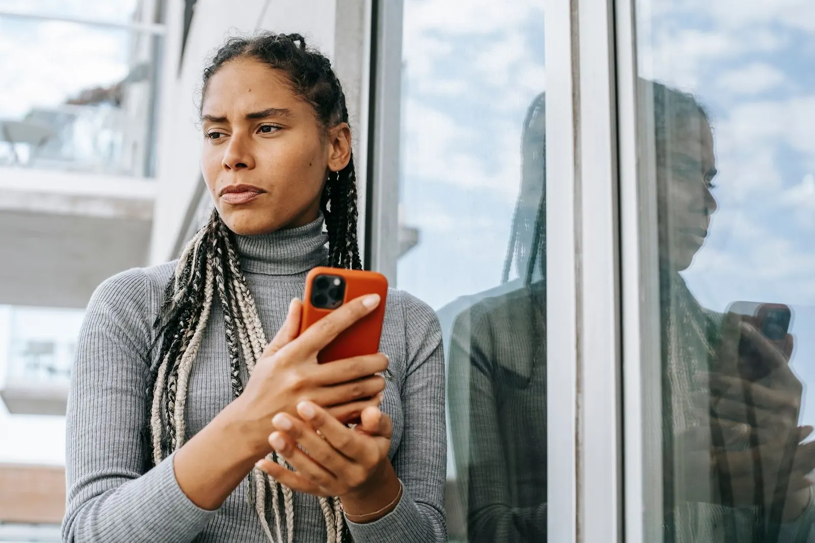 Mujer mirando el móvil pensativa porque Tauro te ignora sin dar explicaciones