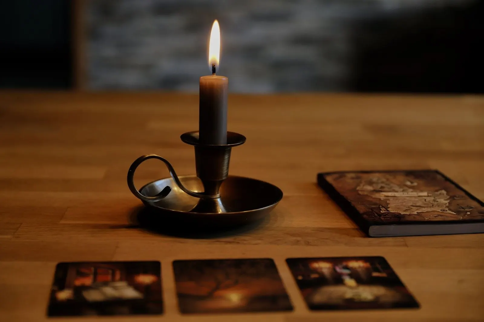 Cartas de tarot junto a velas y una libreta para anotar la lectura