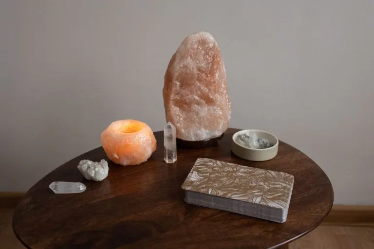 Altar personal sobre una mesa con minerales, una luz y una baraja