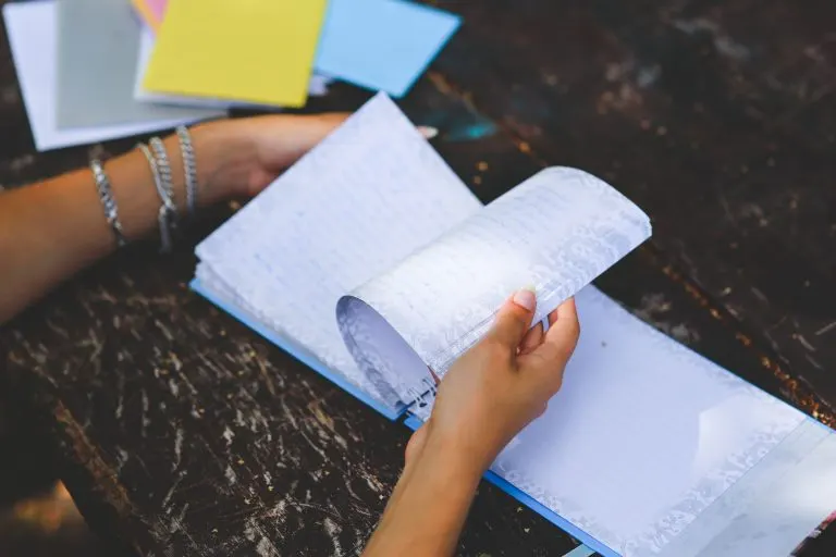Manos revisando las páginas de un diario de símbolos personales