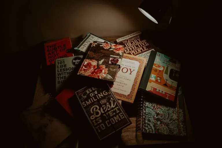 Libros bajo una lámpara en un rincón de lectura