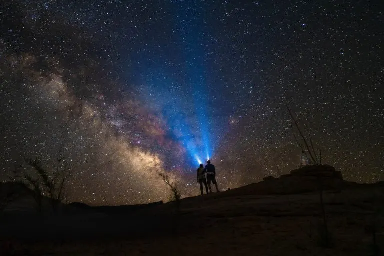 Pareja mirando el cielo estrellado juntos, símbolo de la sinastría entre dos cartas natales
