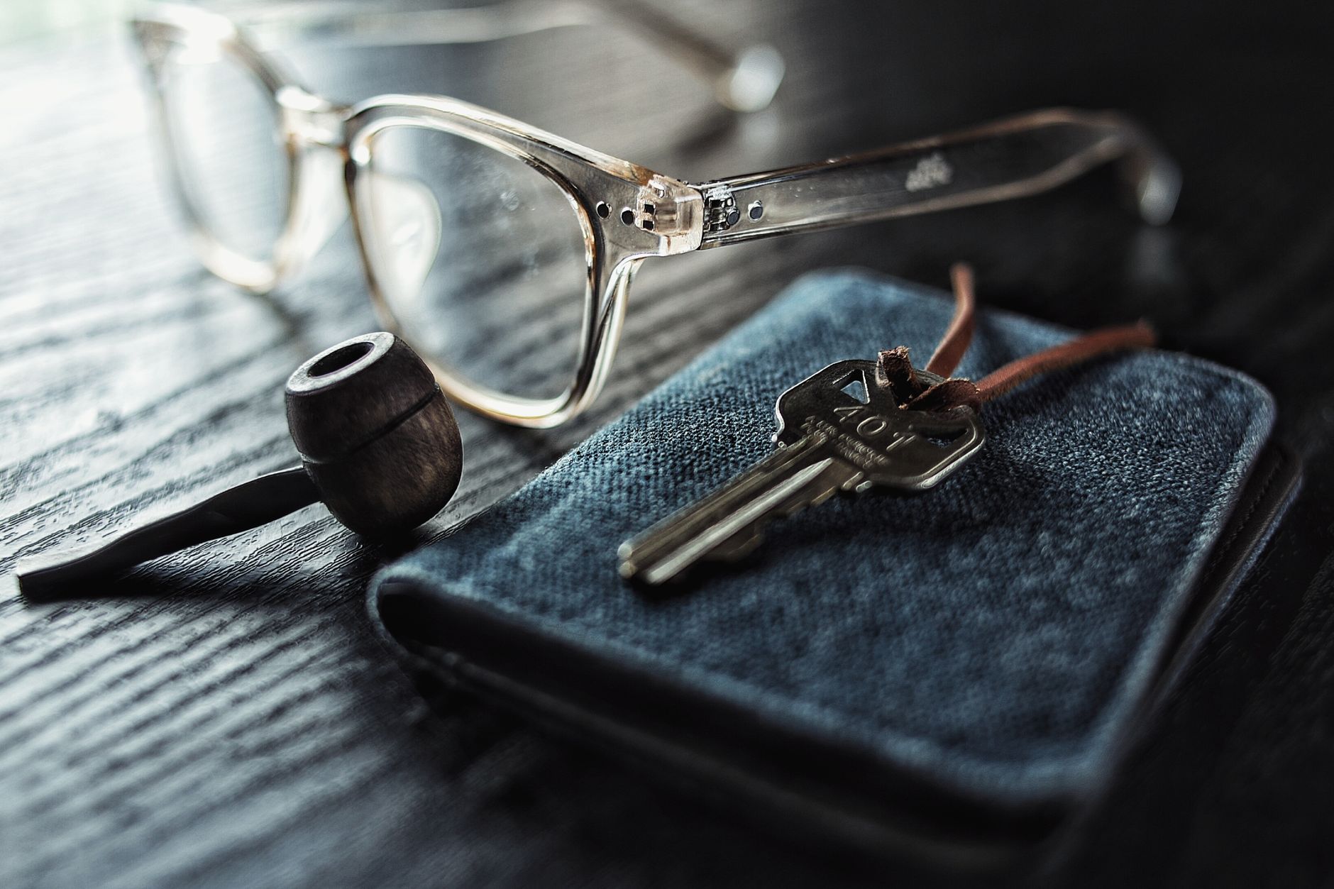 Cómo limpiar objetos personales de energía Llaves sobre una funda oscura junto a unas gafas y una pipa