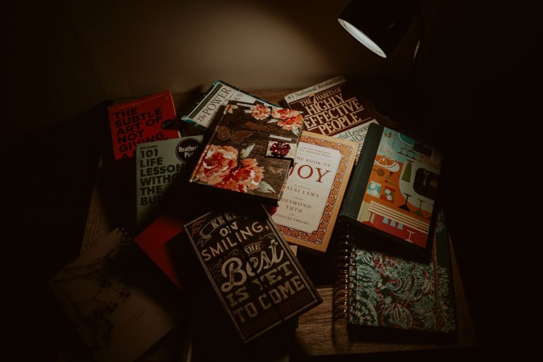 Libros bajo una lámpara en un rincón de lectura