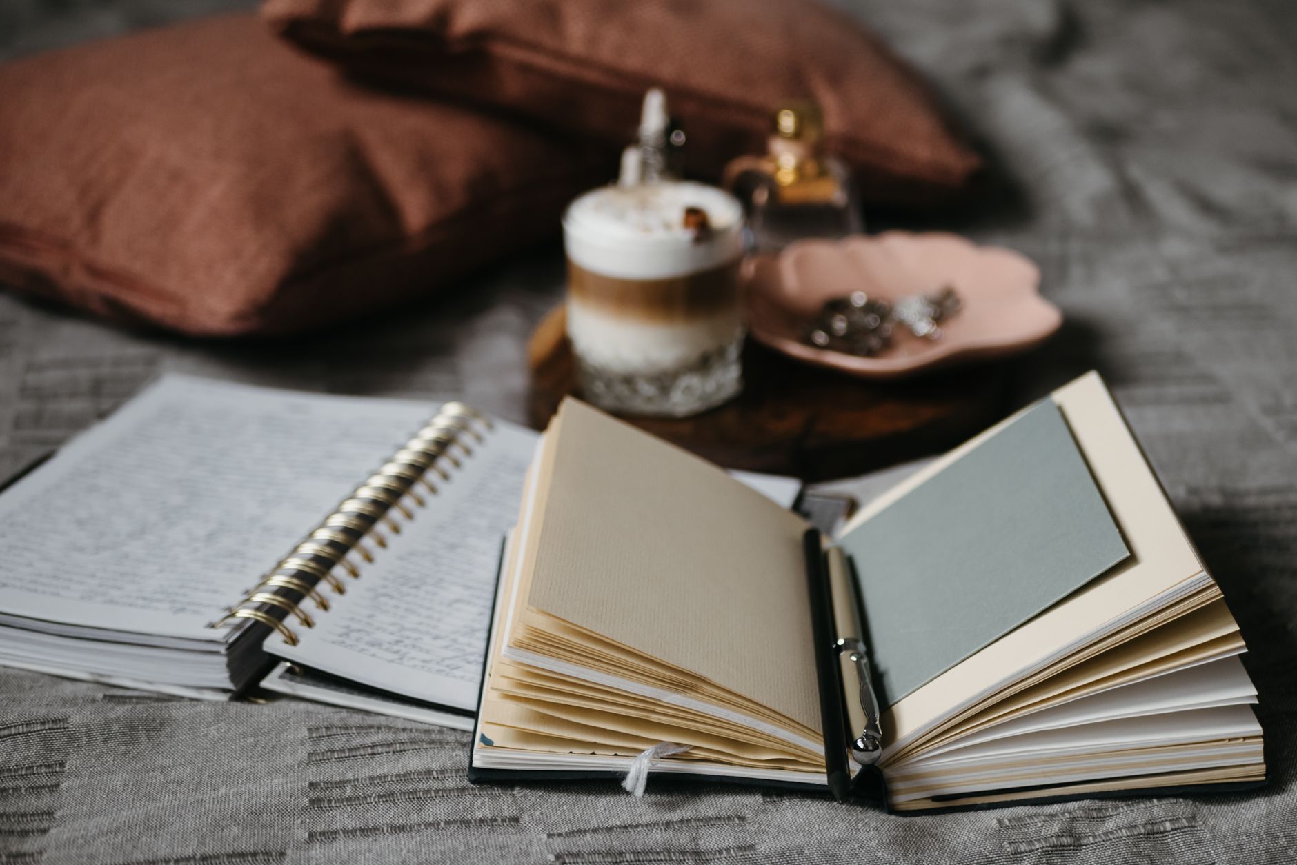 Cómo crear un rincón de reflexión en casa Cuadernos abiertos y lápices sobre una superficie textil
