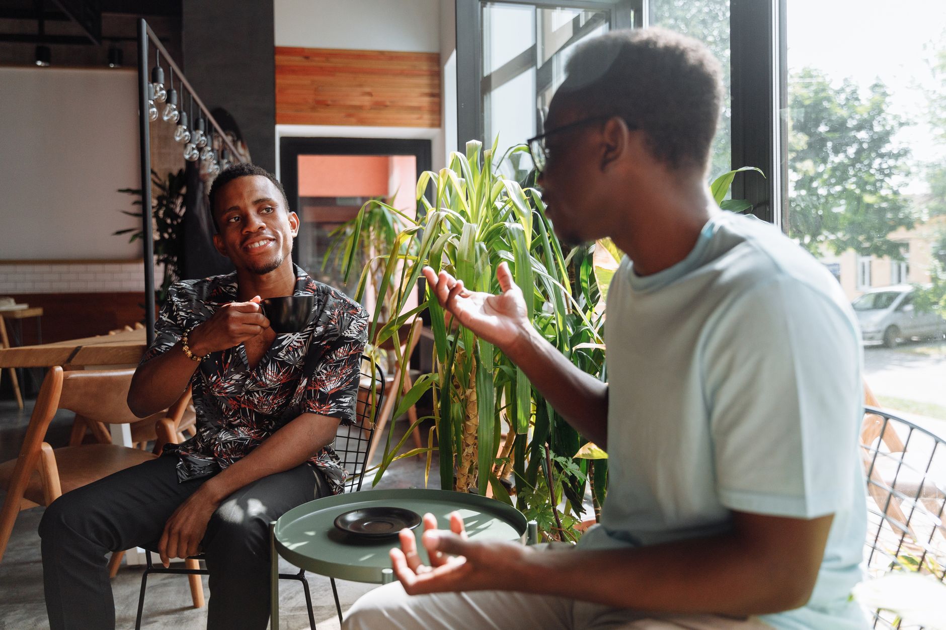 Amistad vs Amor: Cuando Acuario se enamora de su mejor amigo Dos amigos conversando en una cafetería con gesto cercano y atento