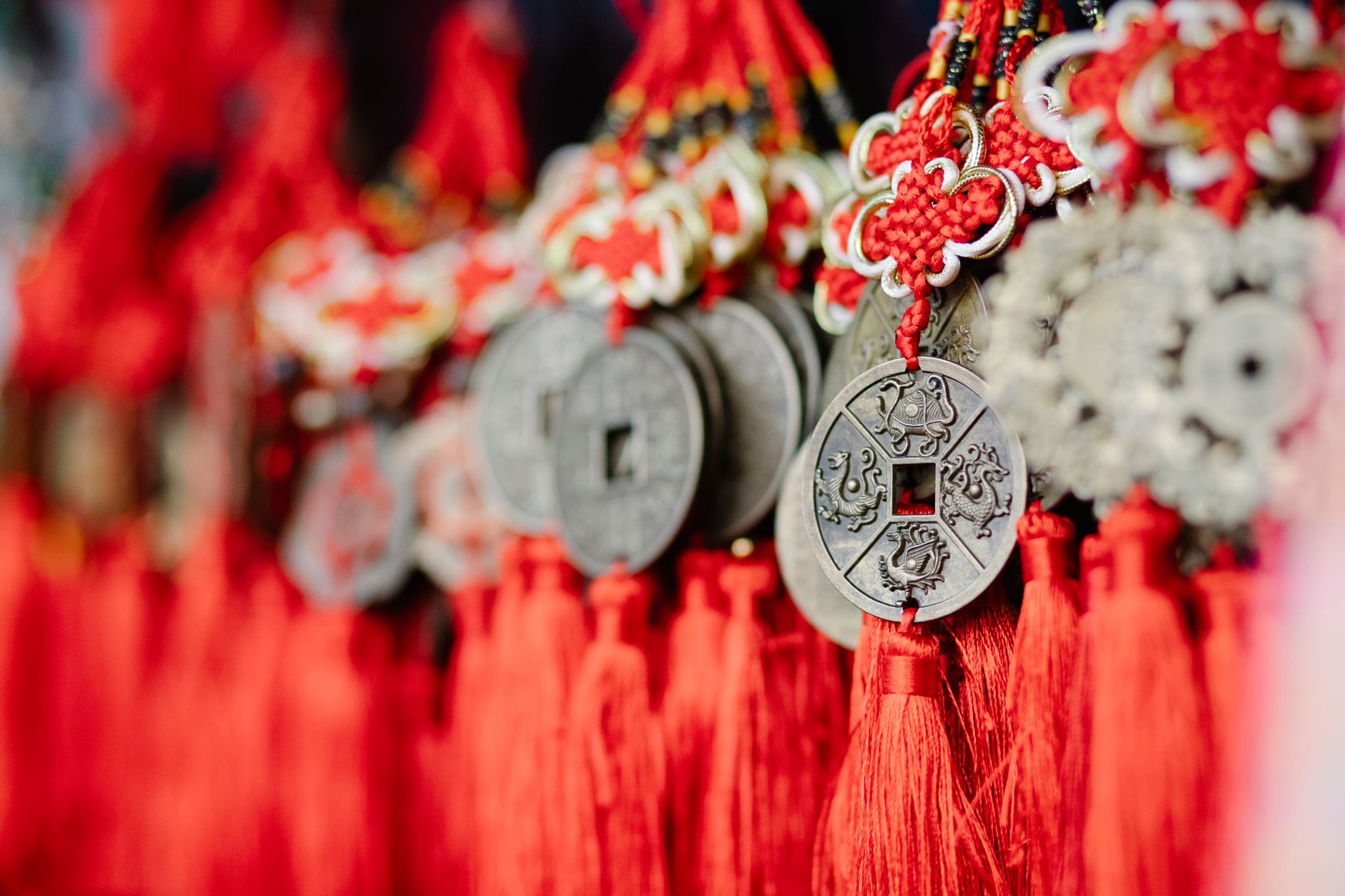 Amuleto de la moneda china con hilo rojo: cómo activarlo Tres monedas chinas de feng shui atadas con cordón rojo y nudo místico