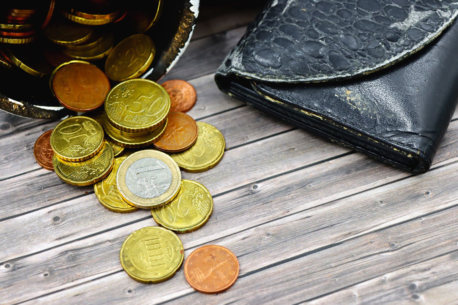 Amuleto de la moneda china con hilo rojo: cómo activarlo Cartera de piel abierta con monedas, lugar habitual para llevar el amuleto chino