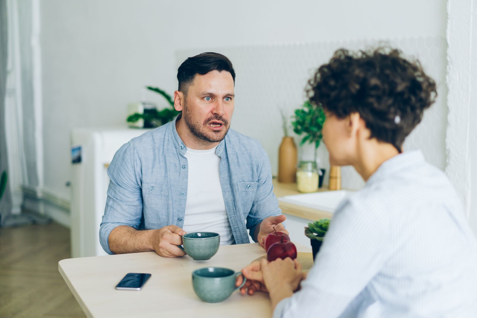 Compatibilidad por fecha de nacimiento: cómo se calcula Pareja conversando con un café mientras comparan sus fechas de nacimiento y signos